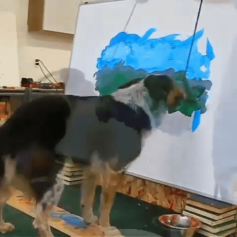 Dog painting a landscape with a little help from his owner